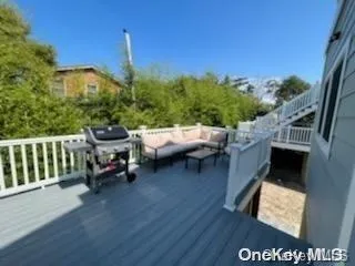 a view of a patio with table and chairs with wooden floor and fence