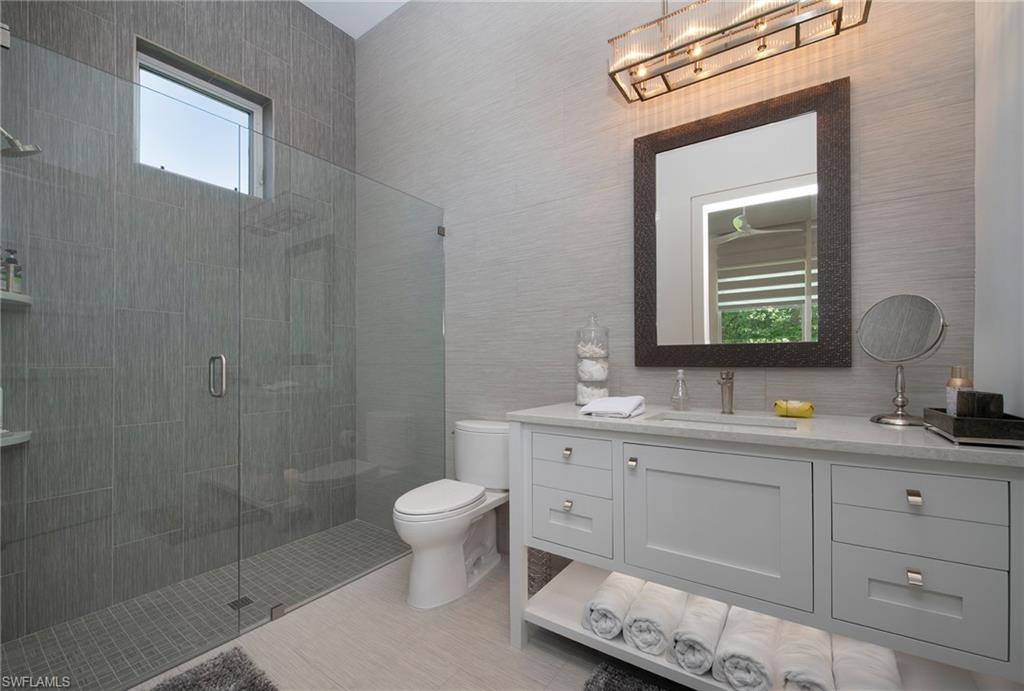 581 Myrtle Road Naples, FL 34108 - Photo 21 of 39 a bathroom with a toilet a sink and mirror