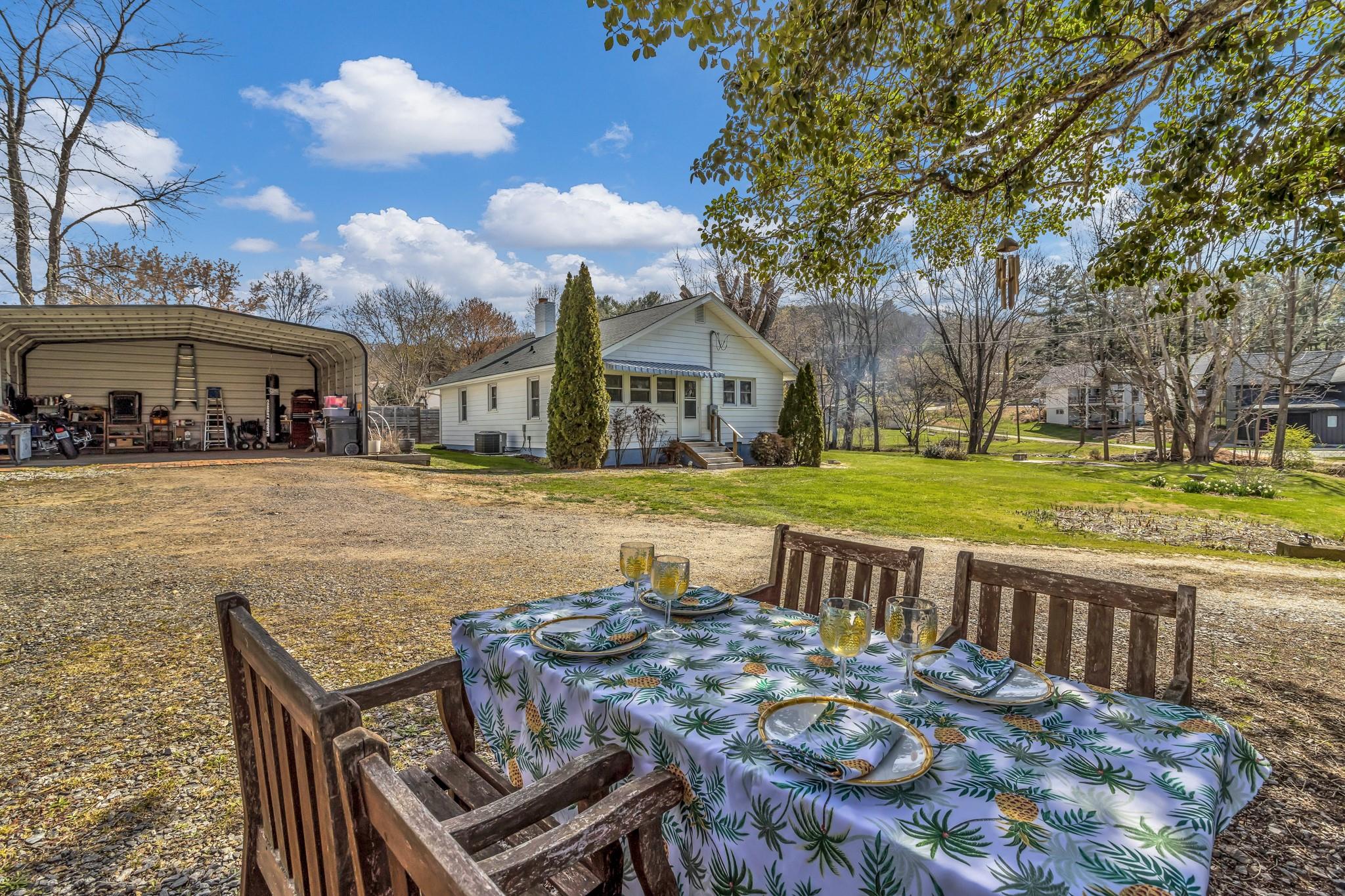 994 Riceville Road Asheville, NC 28805 - Photo 15 of 45 a view of a patio with table and chairs near a yard