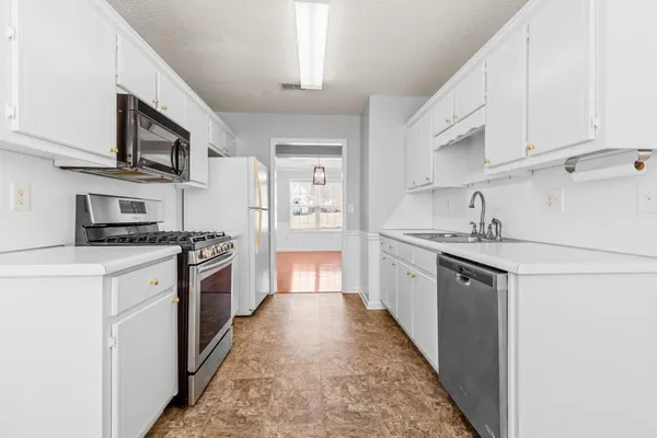 a large kitchen with stainless steel appliances granite countertop a stove a sink dishwasher and a refrigerator