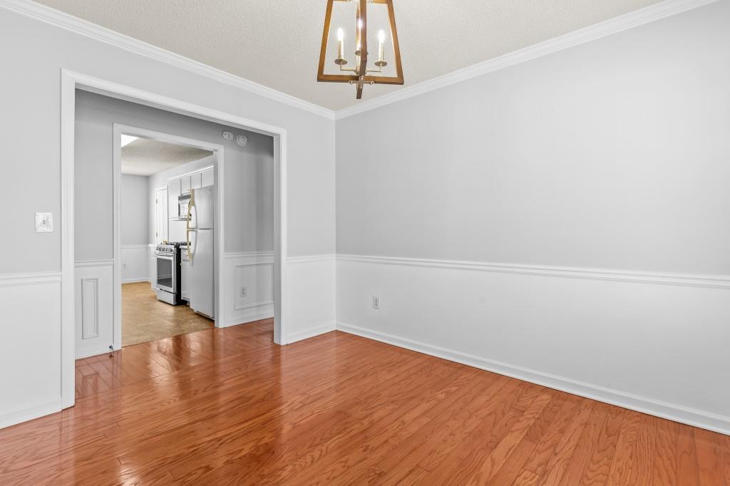 1707 Mountain Fort Way Dacula, GA 30019 - Photo 16 of 34 a view of a hallway with wooden floor and a chandelier