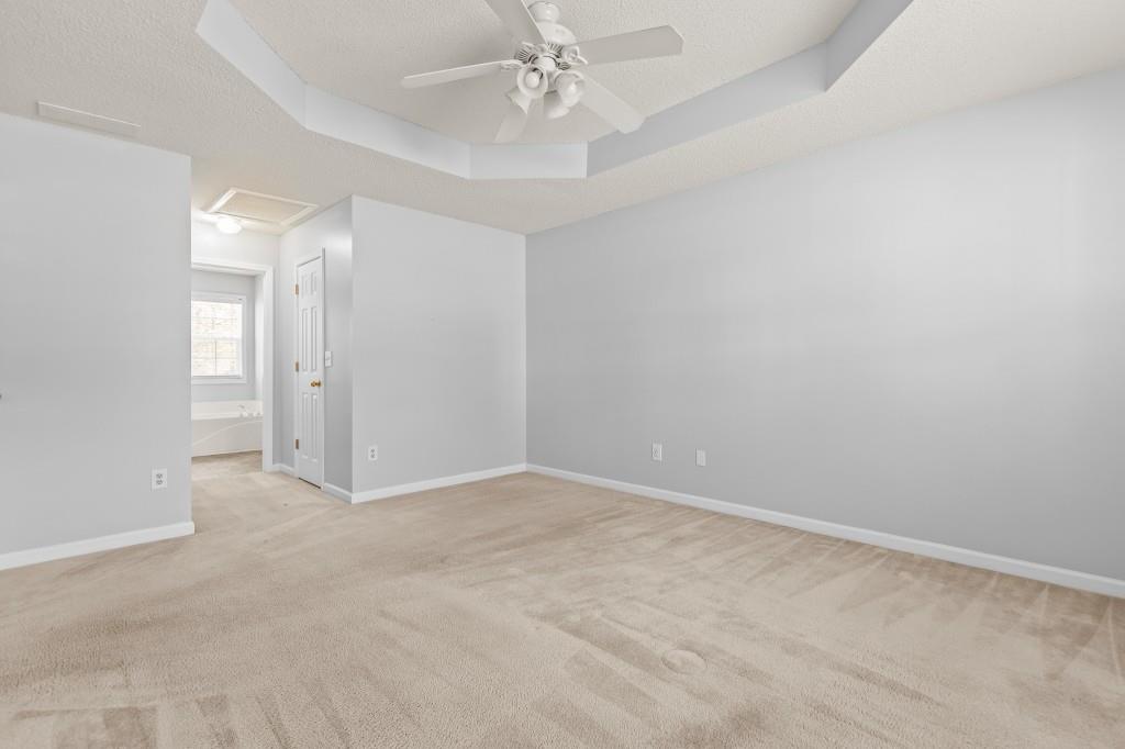 1707 Mountain Fort Way Dacula, GA 30019 - Photo 18 of 34 an empty room with chandelier fan and windows