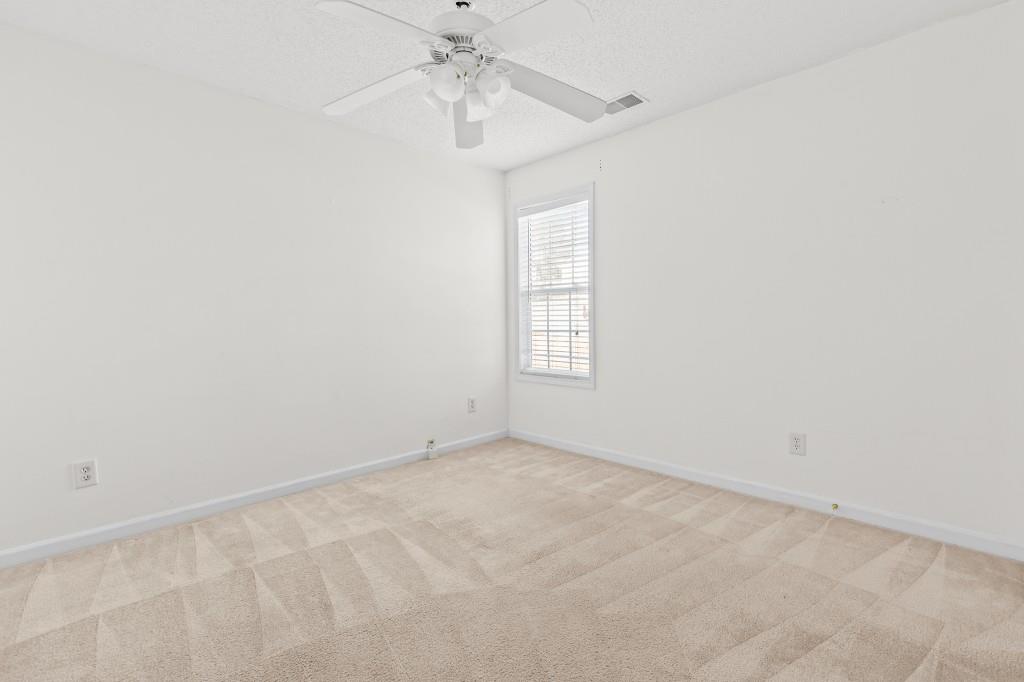 1707 Mountain Fort Way Dacula, GA 30019 - Photo 22 of 34 an empty room with windows and chandelier fan