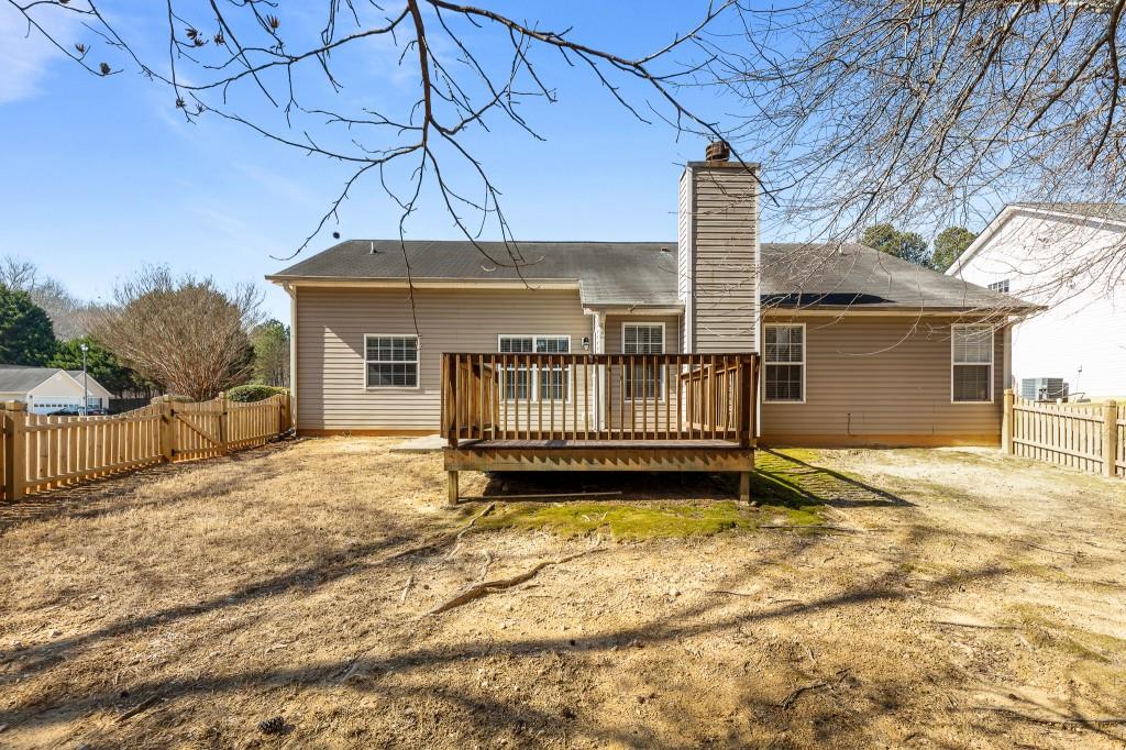 1707 Mountain Fort Way Dacula, GA 30019 - Photo 29 of 34 a view of a house with a wooden deck and a yard