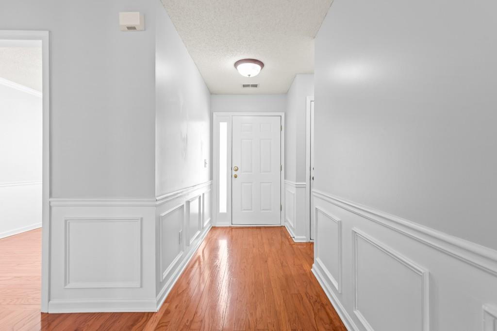 1707 Mountain Fort Way Dacula, GA 30019 - Photo 3 of 34 a view of a hallway with wooden floor and staircase