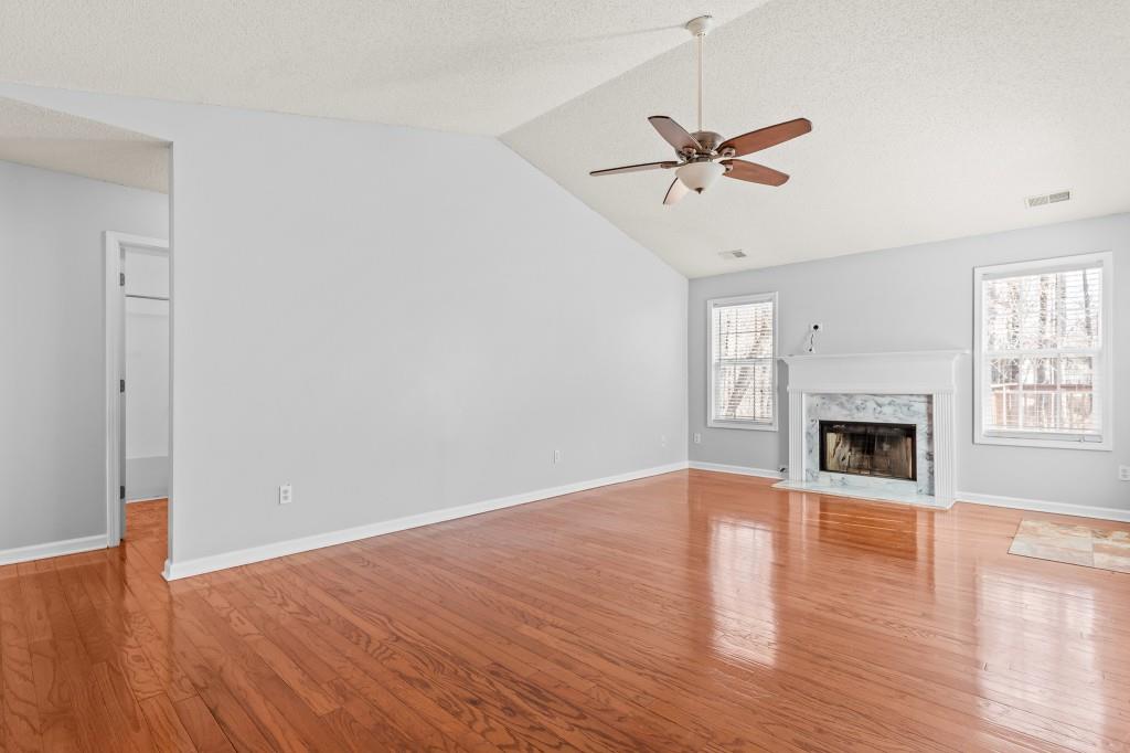 1707 Mountain Fort Way Dacula, GA 30019 - Photo 4 of 34 a view of a livingroom with a fireplace a ceiling fan and windows