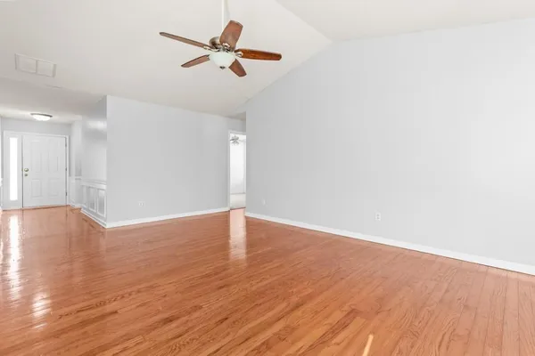 a view of empty room with wooden floor