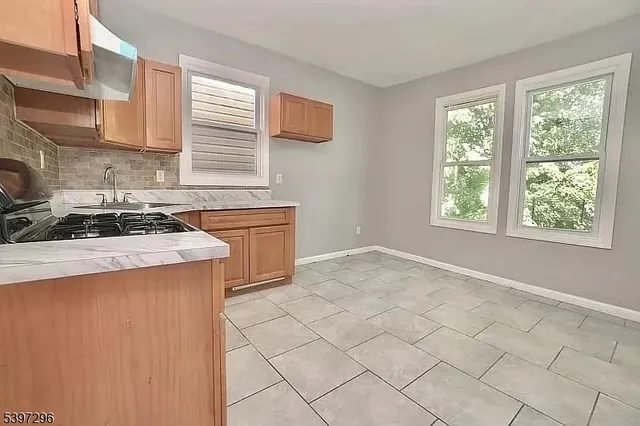 a kitchen with a stove a sink a refrigerator and cabinets