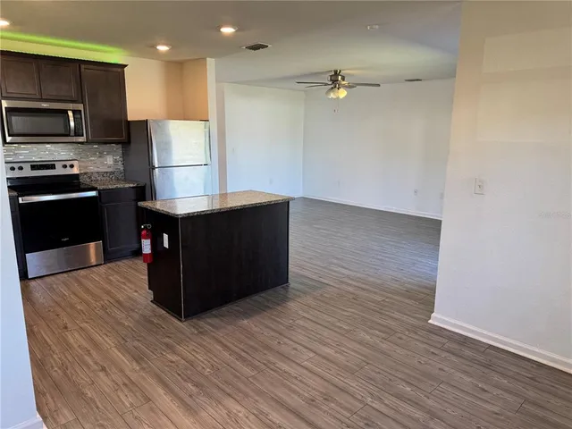 a kitchen with stainless steel appliances a refrigerator and a stove top oven