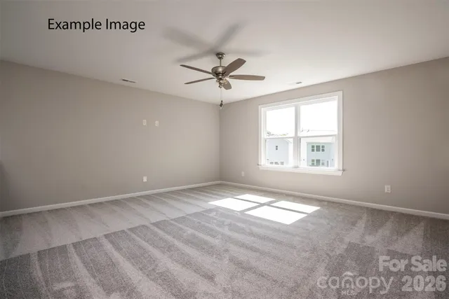 an empty room with windows and ceiling fan