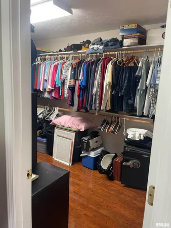 a view of walk in closet with clothes and shoes