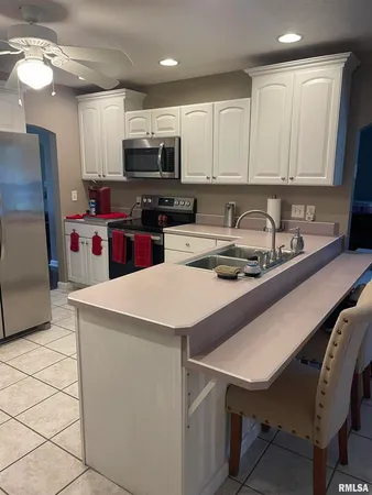a kitchen with stainless steel appliances a stove a sink a microwave and cabinets