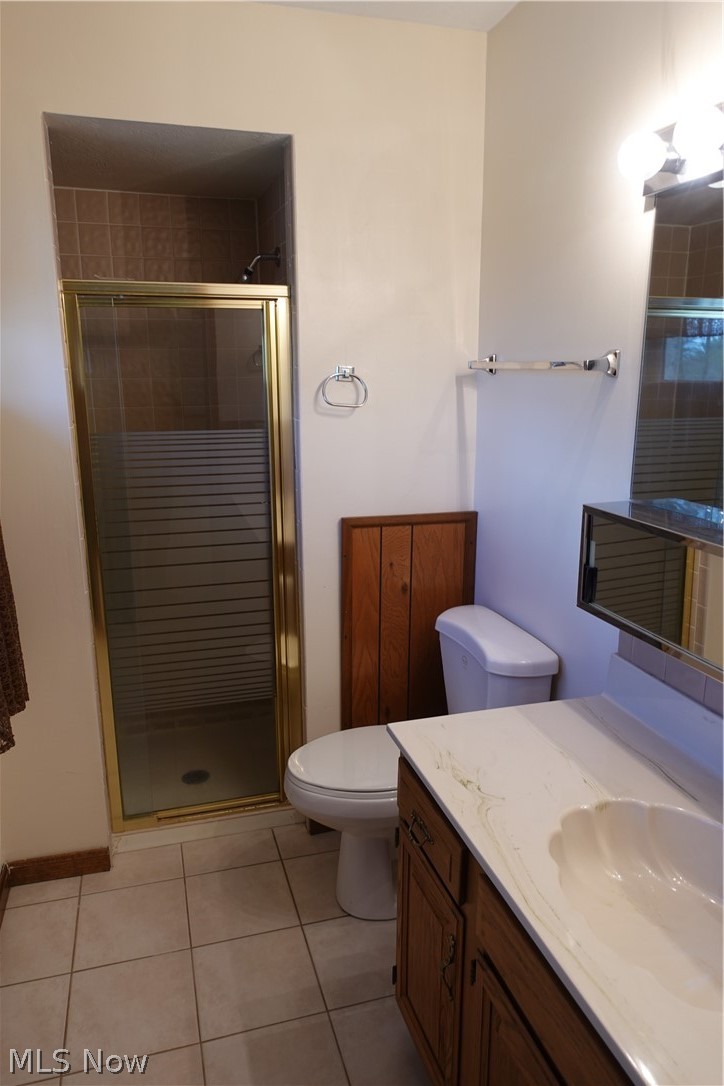 15488 Hatfield Road Rittman, OH 44270 - Photo 25 of 36 Bathroom featuring tile flooring, a shower with door, vanity, and toilet