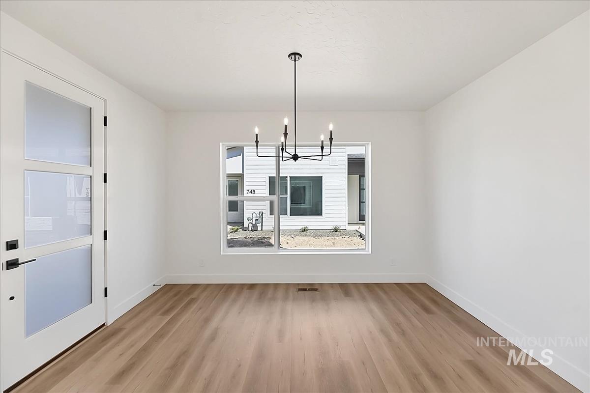 776 South Calhoun Lane Star, ID 83669 - Photo 18 of 49 Bright interior space featuring wood-finish flooring, white walls, and a modern black chandelier