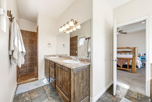7776 Wagon Road East St. George, UT 84770 - Photo 25 of 76 Ensuite bathroom with stone tile flooring, double vanity, a walk in shower, and a ceiling fan
