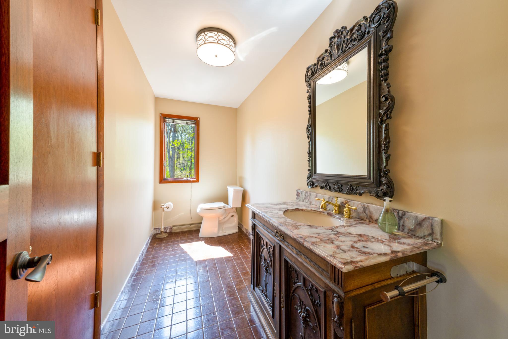 3446 Honeysuckle Road Bethlehem, PA 18015 - Photo 26 of 80 a bathroom with a granite countertop sink and a mirror