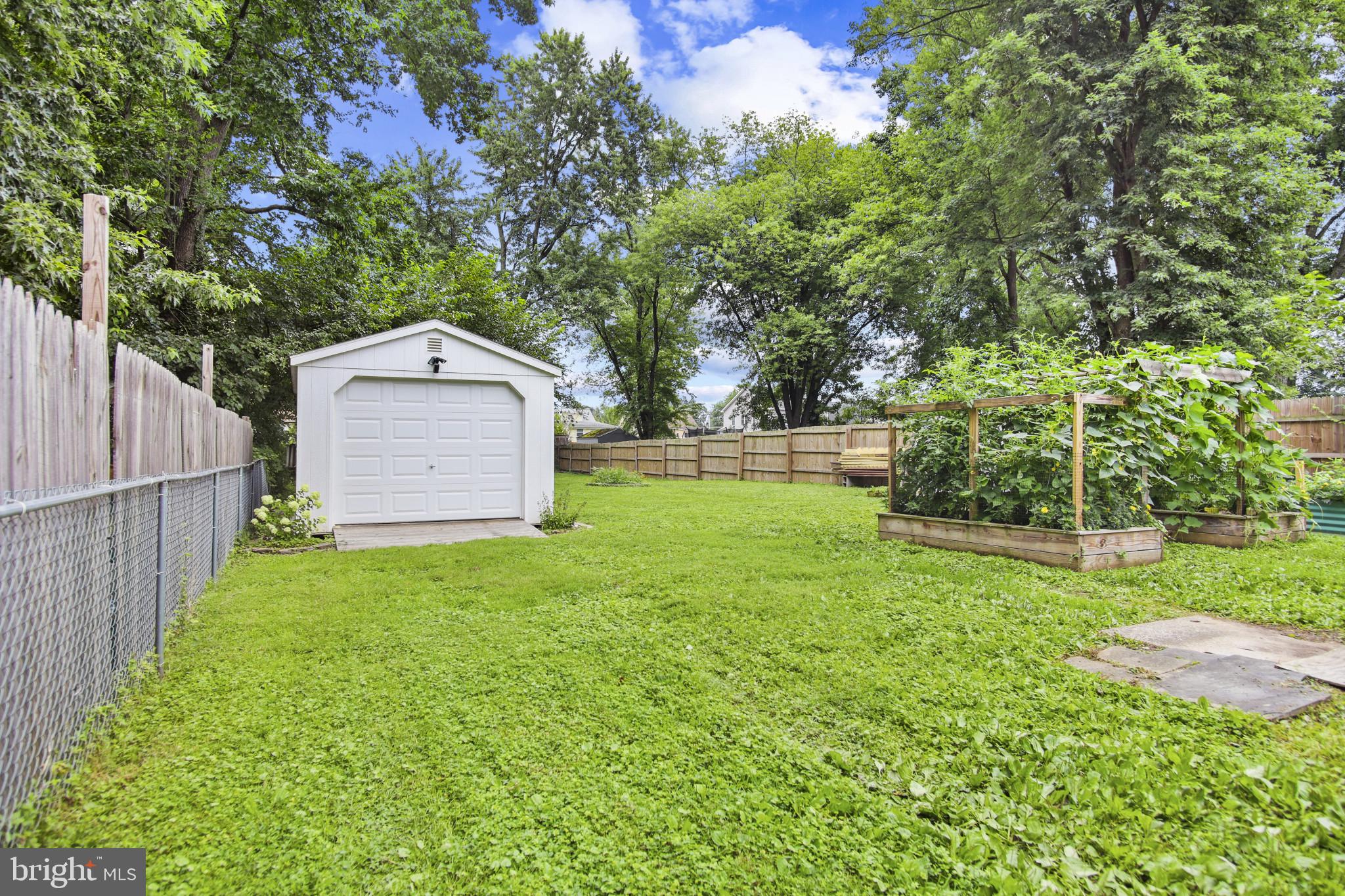 317 Wye Road Essex, MD 21221 - Photo 11 of 35 a view of a backyard with large trees and wooden fence