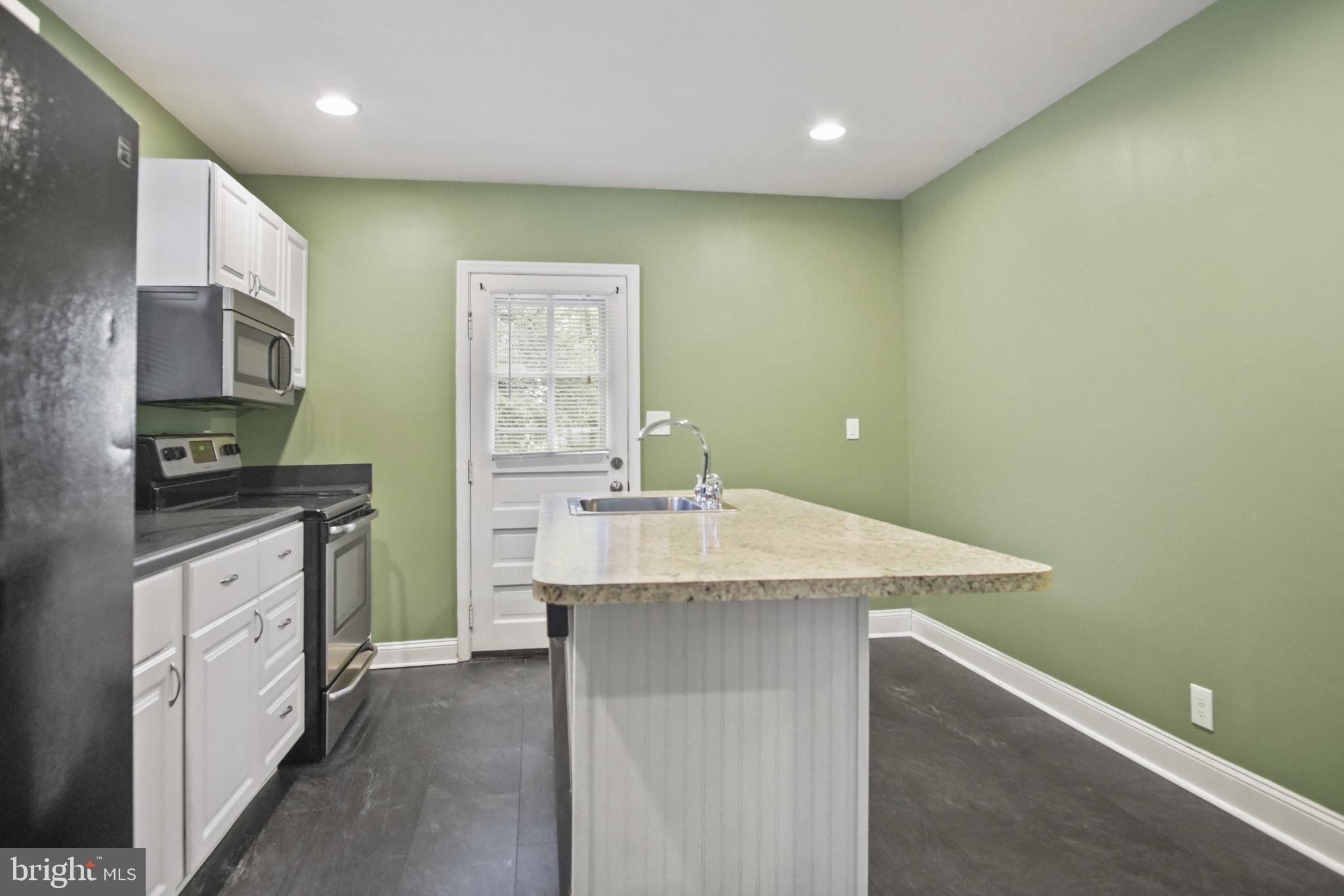 317 Wye Road Essex, MD 21221 - Photo 14 of 35 a kitchen with stainless steel appliances granite countertop a sink and dishwasher a stove top oven with wooden floor