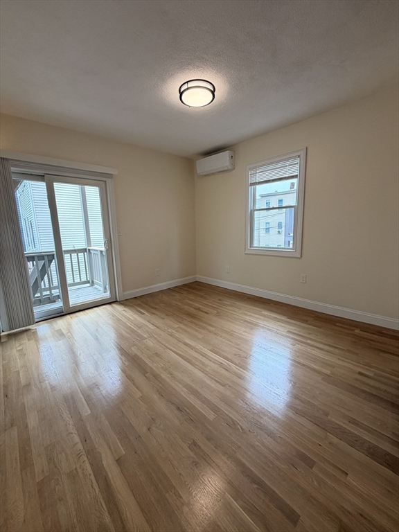 26 Brooks Street, Unit 2 Boston, MA 02128 - Photo 6 of 12 an empty room with wooden floor and windows