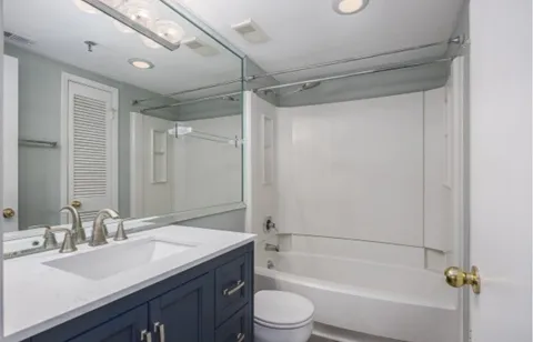 a bathroom with a granite countertop sink toilet and shower
