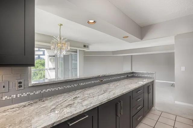 a bathroom with a granite countertop sink and a large mirror