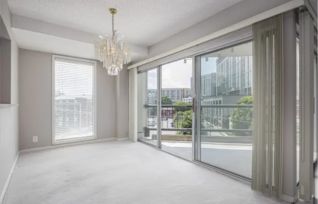 a view of an empty room with windows and chandelier