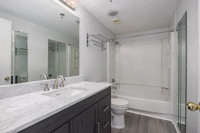 a bathroom with a granite countertop sink toilet and shower