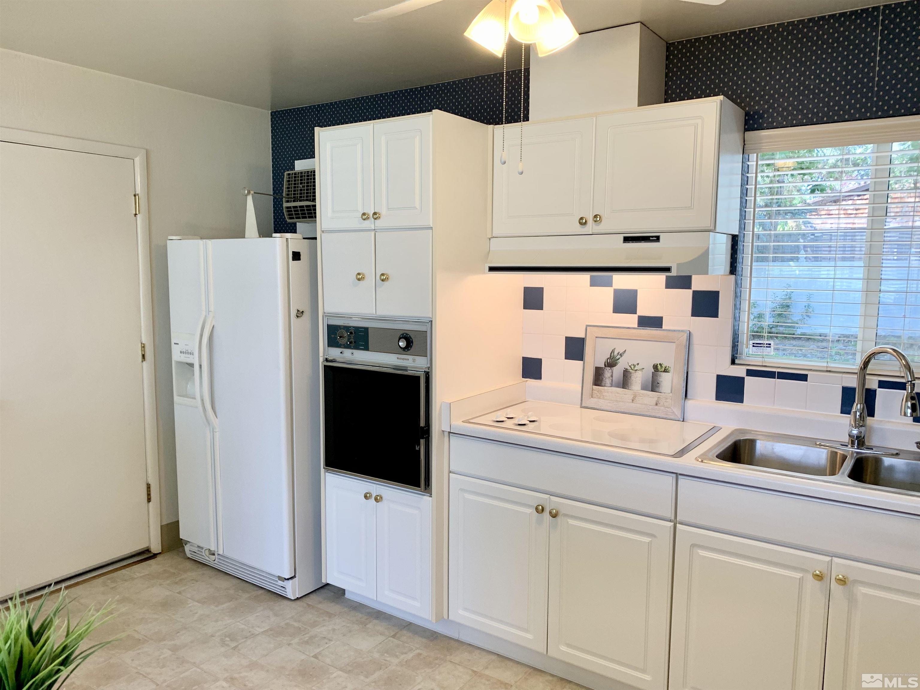 2540 Riviera Street Reno, NV 89509 - Photo 8 of 27 a kitchen with stainless steel appliances white cabinets and a refrigerator