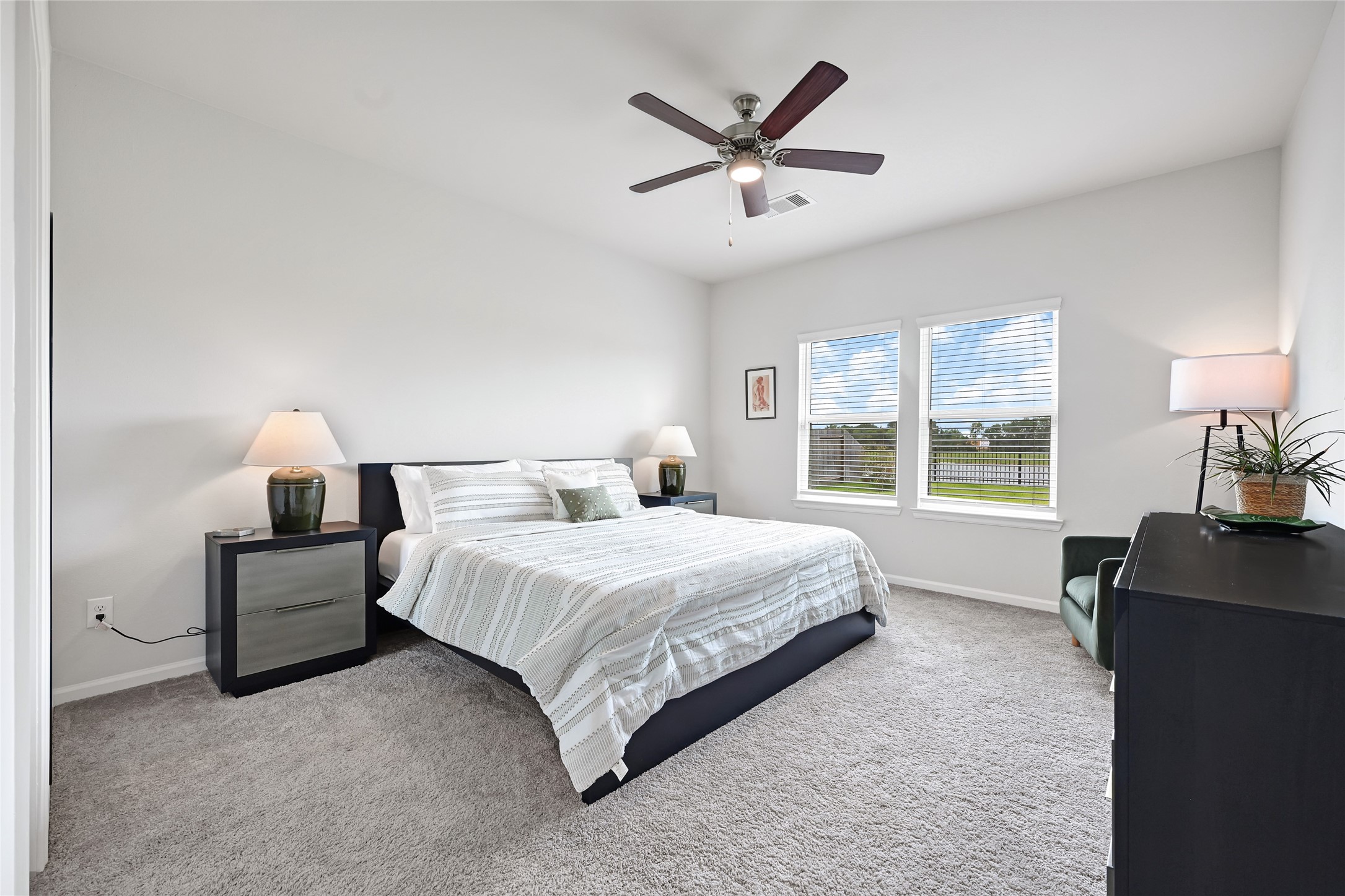 5702 Transformation Trail Katy, TX 77493 - Photo 15 of 32 a spacious bedroom with a bed a chandelier and a large window