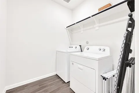 a kitchen with stainless steel appliances granite countertop a stove top oven a sink a dining table and chairs with wooden floor