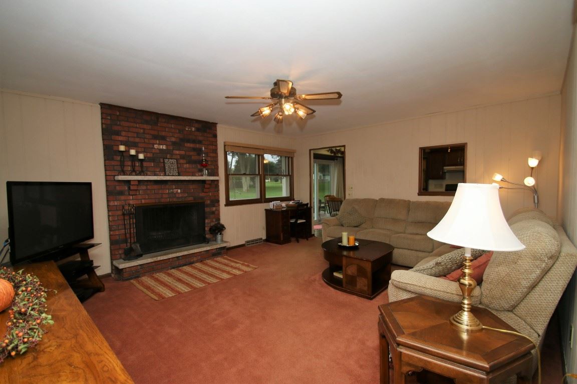 8131 Clockview Road Rockford, IL 61108 - Photo 12 of 25 a living room with furniture a fireplace and a flat screen tv
