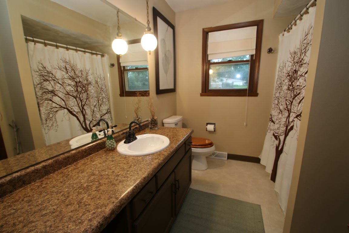8131 Clockview Road Rockford, IL 61108 - Photo 18 of 25 a bathroom with a granite countertop sink mirror and a toilet