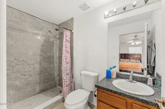 a bathroom with a granite countertop sink toilet mirror and shower