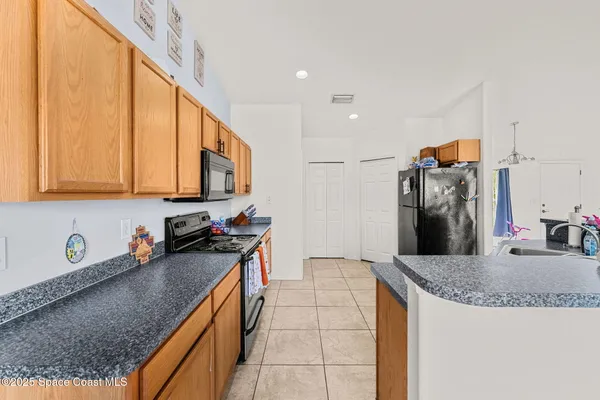 a kitchen with stainless steel appliances granite countertop a sink a stove and refrigerator