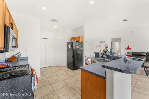 a kitchen view with granite countertop a sink stove and refrigerator