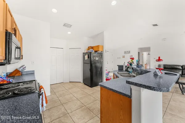 a kitchen view with granite countertop a sink stove and refrigerator