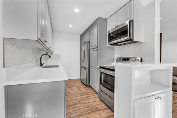 a kitchen with stainless steel appliances a sink stove and microwave