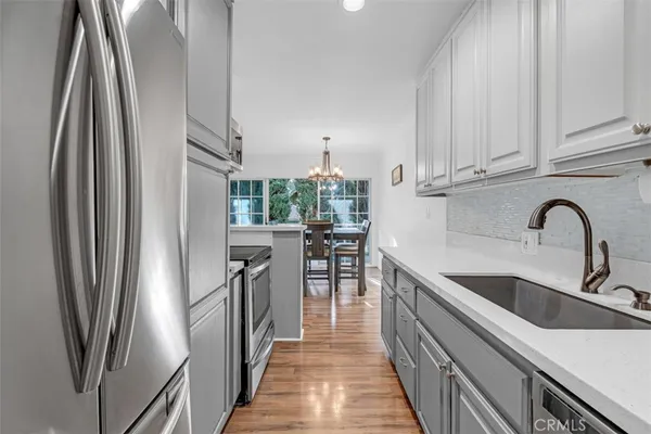 a kitchen with stainless steel appliances granite countertop a refrigerator and a sink
