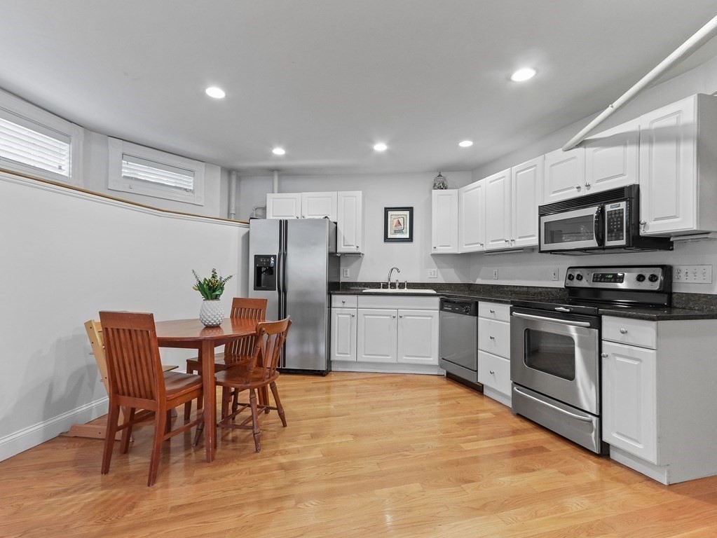 16 Garrison Road, Unit 8 Brookline, MA 02445 - Photo 8 of 20 a kitchen with stainless steel appliances granite countertop a white table chairs and a refrigerator