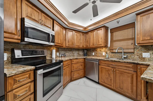 a bathroom with a granite countertop sink and a refrigerator