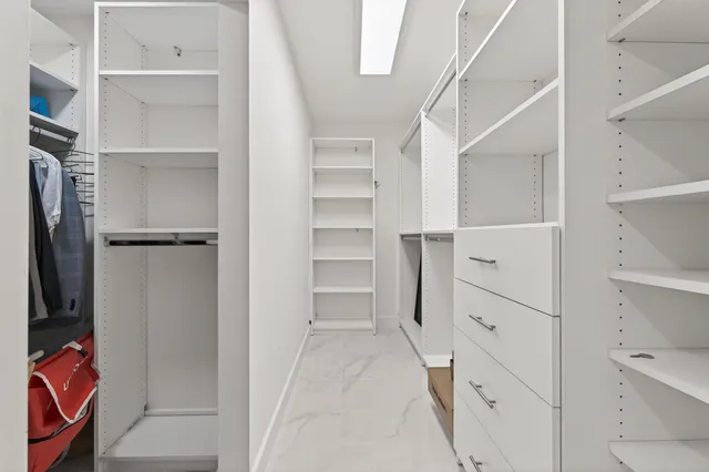 a bathroom with a granite countertop sink a toilet a mirror and a window