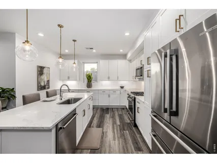 a kitchen with kitchen island a counter top space a sink stainless steel appliances and cabinets