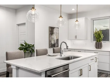 a kitchen with a sink a counter space and cabinets
