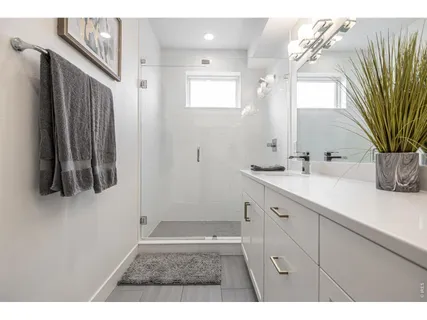a bathroom with a sink a mirror and shower