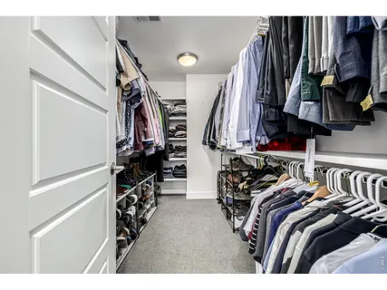 a view of walk in closet with clothes and shoes