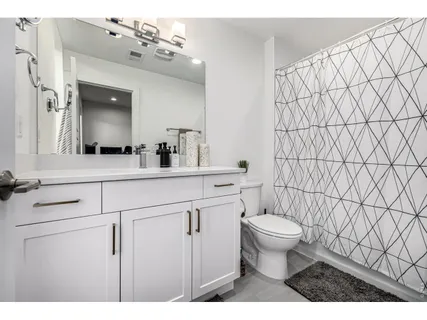 a bathroom with a sink vanity mirror and toilet