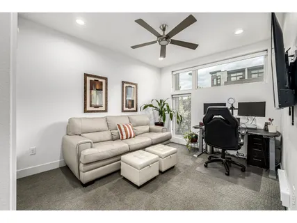 a living room with furniture a ceiling fan and a rug