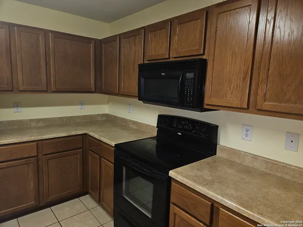 a kitchen with granite countertop cabinets and black appliances