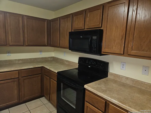a kitchen with granite countertop cabinets and black appliances