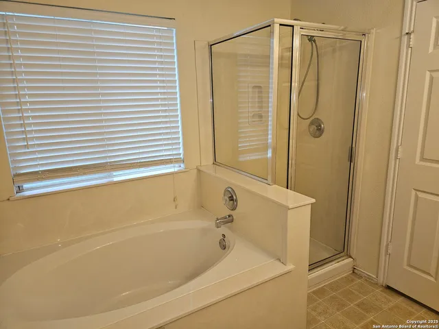 a bathroom with a shower and a bath tub